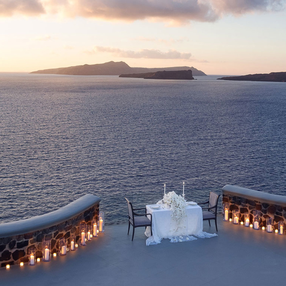 Romantic candlelit dinner setup overlooking the Aegean Sea at Grand Ambassador in Santorini